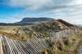 Wooden fence by dunes. Knocknarea hill in the background. County Sligo, Ireland. Blue cloudy sky, Nobody Royalty Free Stock Photo