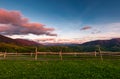 Wooden fence on a grassy hill at sunset Royalty Free Stock Photo