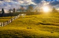 Fence on grassy hillside in autumn at sunset Royalty Free Stock Photo