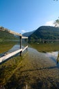 Wooden fence leading to a lake in mountains, with clean fresh clear water. Italian Alps. Lombardy. Italy. September 2023 Royalty Free Stock Photo