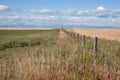 Wooden Fence Leading to Mountains and Prairie Sky Royalty Free Stock Photo