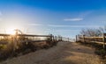 Wooden fence leads to beach near lighthouse in Cape May, NJ, on a sunny morning