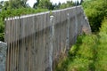 Wooden fence made of natural planks. the columns are made of roughly worked gray granite. fencing land in the mountains. meadow tr Royalty Free Stock Photo