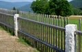 Wooden fence made of natural planks. the columns are made of roughly worked gray granite. fencing land in the mountains. meadow tr Royalty Free Stock Photo