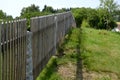 Wooden fence made of natural planks. the columns are made of roughly worked gray granite. fencing land in the mountains. meadow tr Royalty Free Stock Photo