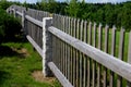 Wooden fence made of natural planks. the columns are made of roughly worked gray granite. fencing land in the mountains. meadow tr Royalty Free Stock Photo