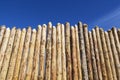 Wooden fence made of sharpened planed logs. Royalty Free Stock Photo