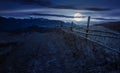 Wooden fence in mountainous countryside at night