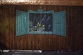 Israel, Dimona, 2018 - A wooden fence and a painted window with shutters and a bouquet of flowers in the evening