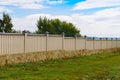 Wooden fence painted yellow with a stone base on the day Royalty Free Stock Photo