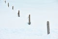 Wooden fence posts in deep snow winter guidance