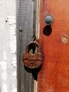 Wooden fence with a red door with a lock. Fence and gate cottages.