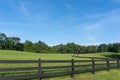A wooden fence runs through a hilly pasture along a dirt road on a farm in Georgia Royalty Free Stock Photo