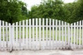 Wooden Fence Solid Privacy in rustic style. Long country style garden fence in countryside. White fence on green grass and the tre