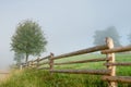 Wooden fence and tree in the fog, scenic landscape countryside Royalty Free Stock Photo