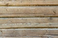 A wooden fence or a wall with a pronounced knotty texture, a natural background of unpainted wood with a rough surface. Blank