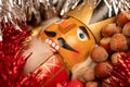 Wooden figure in the form of a soldier for chopping nuts surrounded by colored tinsel and hazelnuts in bulk. New year and Royalty Free Stock Photo