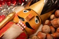 Wooden figure in the form of a soldier for chopping nuts surrounded by colored tinsel and hazelnuts in bulk. New year and Royalty Free Stock Photo