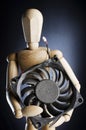 Wooden figure holding computer fan. Royalty Free Stock Photo