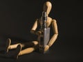 Wooden figure holding an electronic cigarette.