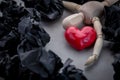 Wooden figure lay down with red heart on grey floor