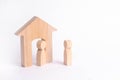 A wooden figure of a man meets a guest on a white background. Wooden house. The concept of an apartment house, real estate. Buying Royalty Free Stock Photo