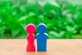 The wooden figure of a man and a woman on a green bokeh background. Concept of love, lovers, romance. Gender relations. Minimalism Royalty Free Stock Photo