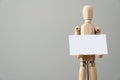 Wooden figure mannequin holding blank white paper