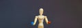 Wooden figure of a mannequin holding a red pill and blue pill on a grey background. Coronavirus, pandemic and epidemic concept.