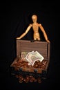 Wooden figure with money box Royalty Free Stock Photo