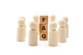 Wooden figures as business team in circle around acronym FAQ Frequently Asked Questions