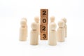 Wooden figures as business team in circle around word 2023