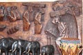 Wooden figures of elephants stand against the background of a wooden panel made by an African artist Royalty Free Stock Photo