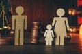 Wooden figures of family with child and gavel on a table close-up. Family law concept Royalty Free Stock Photo