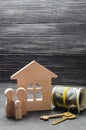 The wooden figures of the family stand near a wooden house, keys Royalty Free Stock Photo