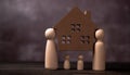 Wooden figures family standing and bear wooden house to Protect and burden the problems to protect the family. The concept of