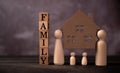 Wooden figures family standing and bear wooden house to Protect and burden the problems to protect the family. The concept of Royalty Free Stock Photo