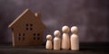 Wooden figures family standing in front of a wooden house. The concept of Protection and safety, Home Security, property insurance Royalty Free Stock Photo
