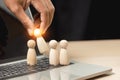 Wooden figures human was chosen leadership of teamwork. man hands are select wooden puppet on laptop to devise strategies for Royalty Free Stock Photo