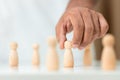 Wooden figures human was chosen leadership of teamwork. man hands are select wooden puppet to devise strategies for appointing Royalty Free Stock Photo