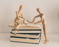 Wooden figures learning and teaching with books, culture and education Royalty Free Stock Photo
