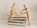 Wooden figures learning and teaching with books, culture and education Royalty Free Stock Photo