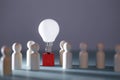 Wooden figures, lightbulb on red cube. Team creativity, idea mockup. Creative approach and lateral thinking, copy space