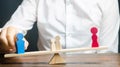 Wooden figures of people on scales. The court decision on custody of the children by one of the parents after the divorce.