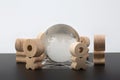 Wooden figures of people standing in a circle around glass globe Royalty Free Stock Photo