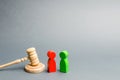 Wooden figures of people standing near the judge`s gavel. Litigation. Business rivals. Conflict of interest. Law and justice. The Royalty Free Stock Photo