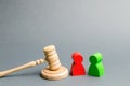 Wooden figures of people standing near the judge`s gavel. Litigation. Business rivals. Conflict of interest. Law and justice. The Royalty Free Stock Photo