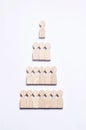 Wooden figures of people on a white background in the form of a pyramid of social hierarchy.