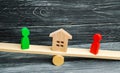 Wooden figures on the scales. clarification of ownership of the house, real estate. court. rivals in business. competition. victor Royalty Free Stock Photo