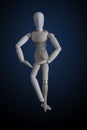 Wooden figurine crossing legs in elegant dancing move on dark ba